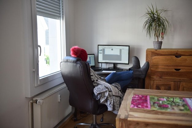A wide shot of a home office setup with a person working on a desktop computer. The screen displays a Black Friday deal on a monitor. The room is well-lit and organized, creating a productive atmosphere.