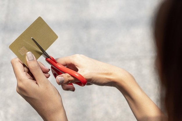A person's hands holding scissors, carefully cutting out a coupon from a printed sheet. The focus is on the detail and precision, highlighting the effort put into saving through coupons.