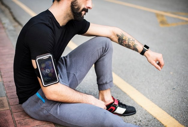 A person running outdoors wearing the Apple Watch Series 11, with the watch face displaying real-time running data such as pace, distance, and heart rate. Sunlight glints off the watch, highlighting its usability in outdoor conditions.