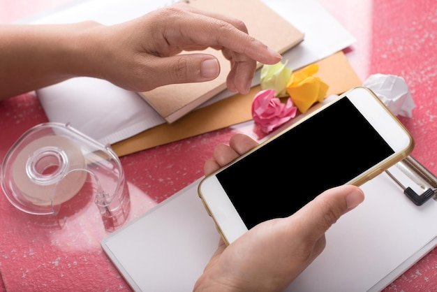 A hand holding a smartphone displaying a free samples website, with a variety of product images and offer details visible on the screen.