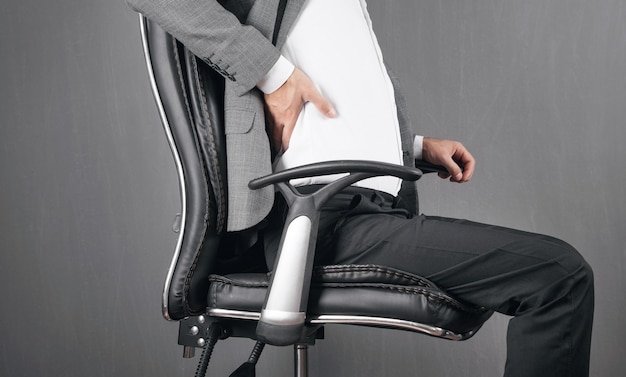 A person adjusting the lumbar support of the Aeron chair, highlighting the chair's adjustability features.