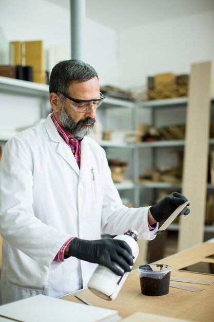 An expert reviewing product specifications with a checklist and testing equipment in a lab setting.