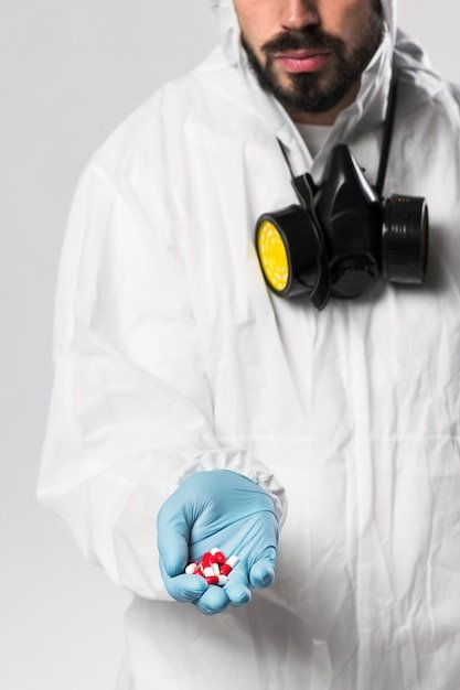 A close-up shot of a person in a lab coat meticulously testing the durability of a smartphone by dropping it from a specific height onto a hard surface. Various testing equipment and other smartphones are visible in the background.