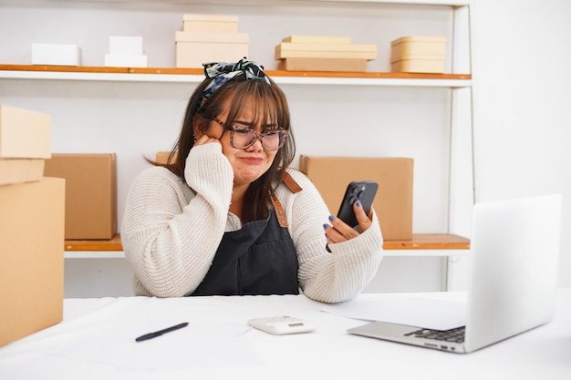 A person looking stressed and frustrated while on a phone call with customer service, surrounded by product manuals and tools, illustrating the time and emotional cost of dealing with faulty products.
