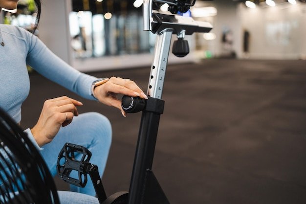 A user adjusting the seat height and handlebar position on the Peloton Bike+, demonstrating the bike's adjustability and ergonomic design.