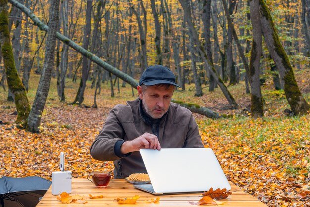 A person sitting at a table, surrounded by a variety of newspapers, magazines, and a laptop, with coupons scattered across the table. The scene should convey a sense of diligent coupon hunting.