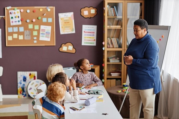 A teacher standing in front of a whiteboard in a classroom, surrounded by engaged students and colorful decorations, with a graphic overlay emphasizing teacher discounts and savings on educational resources.