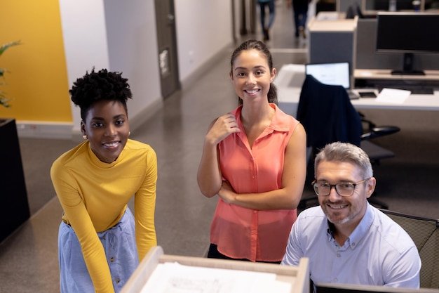 A diverse group of employees smiling and gathered around a company logo, signifying inclusivity in employee benefits programs.
