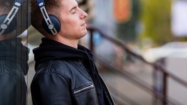 A user wearing the Bose QuietComfort Ultra headphones on a busy city street, highlighting the headphones' ability to block out urban noise. Focus on the headphones and the blurry city background.