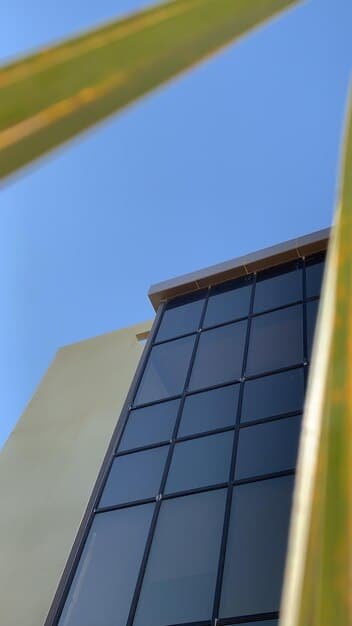 A close-up shot of a modern solar panel installation on a residential rooftop, with the sun shining brightly in the background, emphasizing energy efficiency and sustainability.